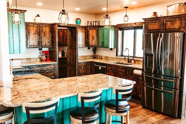 kitchen featuring light stone counters, a sink, stainless steel fridge with ice dispenser, and dishwasher