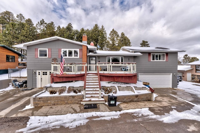 239 Deer Path, Lead, SD 57754 - view of front of house with driveway, a chimney, a deck, a garage, and stairs