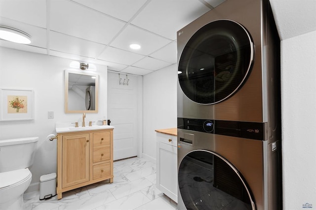 1019 Fulton St, Rapid City, SD 57701 - clothes washing area featuring laundry area, stacked washer and clothes dryer, marble finish floor, baseboards, and a sink