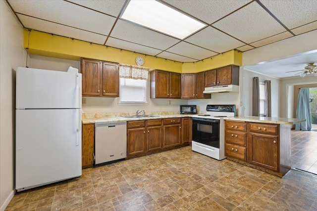 1112 Elkhorn St, Belle Fourche, SD 57717 - kitchen featuring a sink, under cabinet range hood, white appliances, and a paneled ceiling