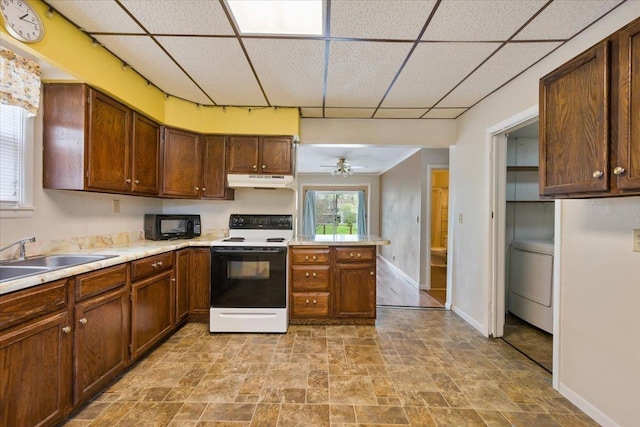 1112 Elkhorn St, Belle Fourche, SD 57717 - kitchen featuring washer / dryer, baseboards, white electric range, under cabinet range hood, and a sink