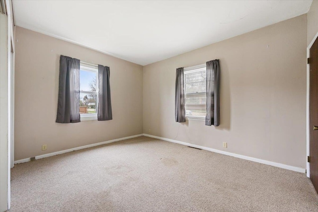 1112 Elkhorn St, Belle Fourche, SD 57717 - carpeted empty room featuring baseboards, a wealth of natural light, and visible vents