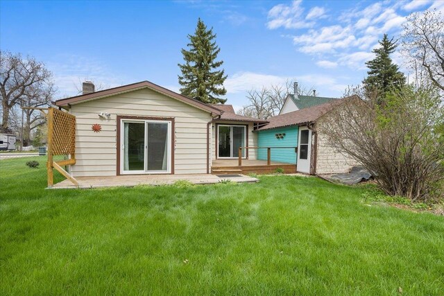 1112 Elkhorn St, Belle Fourche, SD 57717 - rear view of property featuring a lawn, a chimney, and a deck