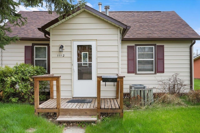 1112 Elkhorn St, Belle Fourche, SD 57717 - rear view of house with central AC, a shingled roof, and a wooden deck