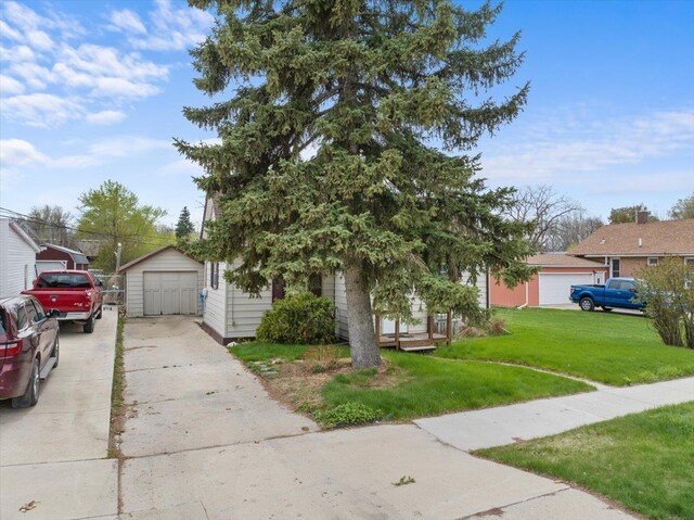 1112 Elkhorn St, Belle Fourche, SD 57717 - obstructed view of property with an outdoor structure, a garage, driveway, and a front yard
