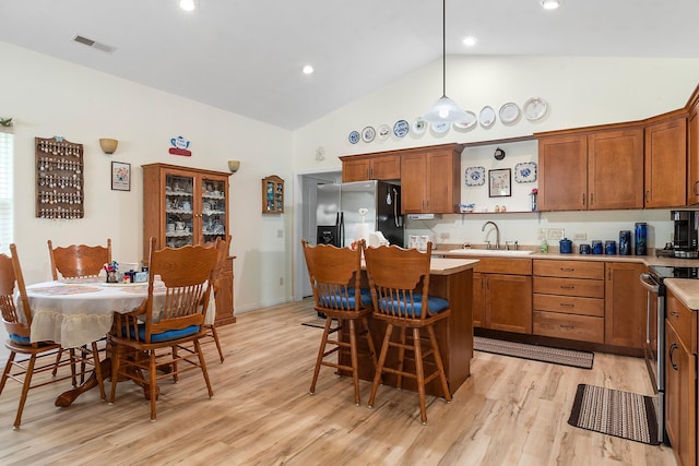 971 Northridge Dr, Rapid City, SD 57701 - kitchen with a kitchen bar, visible vents, appliances with stainless steel finishes, a sink, and high vaulted ceiling