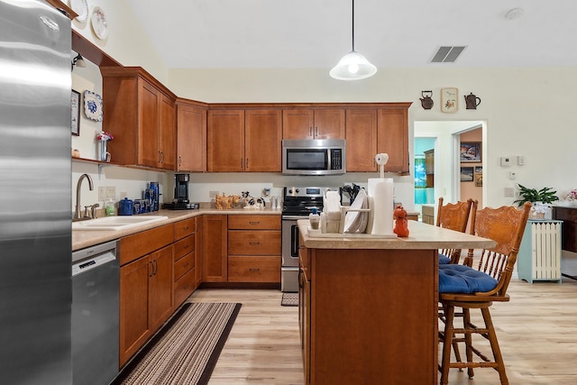 971 Northridge Dr, Rapid City, SD 57701 - kitchen featuring a kitchen breakfast bar, visible vents, a sink, stainless steel appliances, and light wood-style flooring