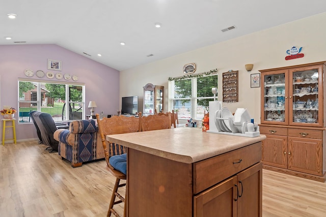 971 Northridge Dr, Rapid City, SD 57701 - kitchen with lofted ceiling, a breakfast bar, open floor plan, light wood-type flooring, and recessed lighting