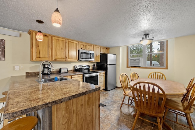 22773 Sunnyside Gulch Rd, Silver City, SD 57702 - kitchen with a textured ceiling, dark countertops, a sink, a peninsula, and stainless steel appliances