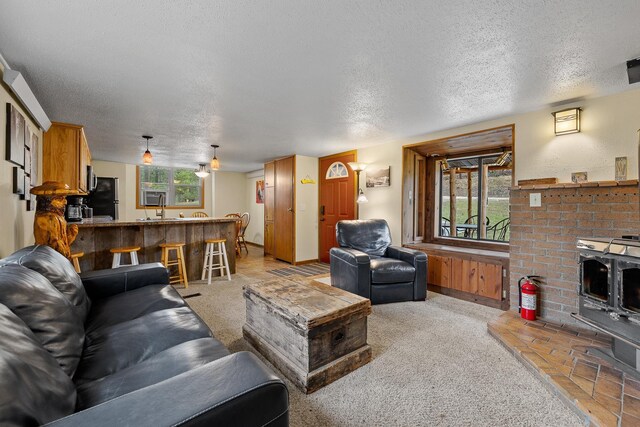 22773 Sunnyside Gulch Rd, Silver City, SD 57702 - living room with indoor bar, a wood stove, a textured ceiling, and light carpet