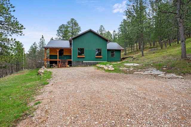 12021 Crook City Rd, Whitewood, SD 57793 - rear view of house with covered porch, metal roof, and dirt driveway