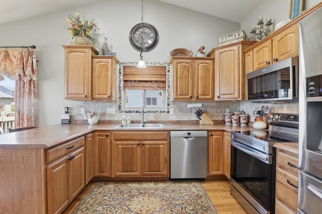 2940 Motherlode Dr, Rapid City, SD 57702 - kitchen with a peninsula, a sink, stainless steel appliances, backsplash, and lofted ceiling
