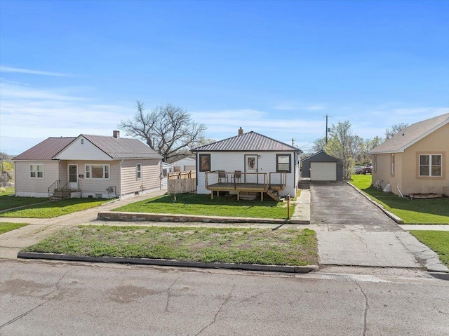 view of front of property with aphalt driveway, a garage, an outbuilding, a front yard, and entry steps
