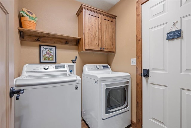 washroom with separate washer and dryer and cabinet space