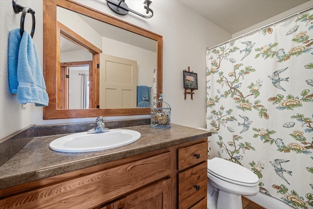 bathroom with toilet, vanity, and a shower with curtain