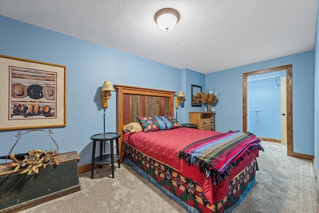 bedroom with carpet, a textured ceiling, and baseboards