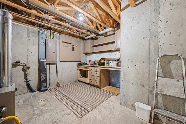 basement featuring electric panel and a workshop area