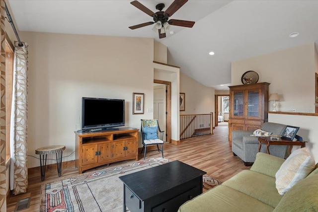 living area featuring lofted ceiling, baseboards, a ceiling fan, and wood finished floors