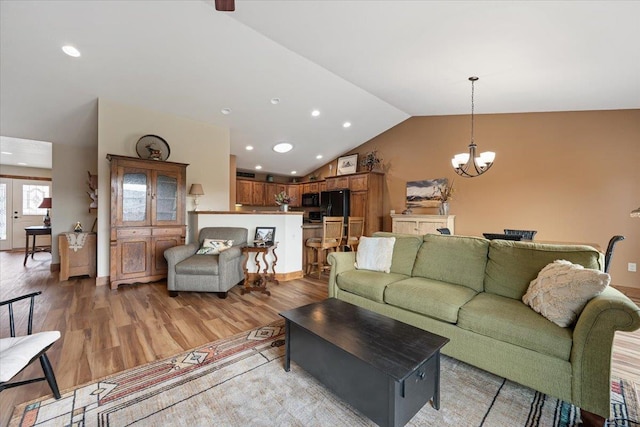 living area with lofted ceiling, light wood finished floors, a chandelier, and recessed lighting