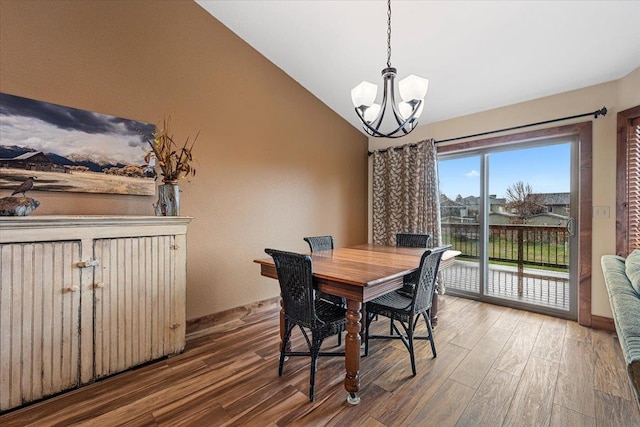 dining area featuring an inviting chandelier, baseboards, wood finished floors, and lofted ceiling