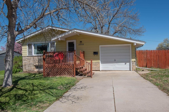 2608 Maple Ave, Rapid City, SD 57701 - view of front facade featuring stone siding, driveway, a front lawn, and fence