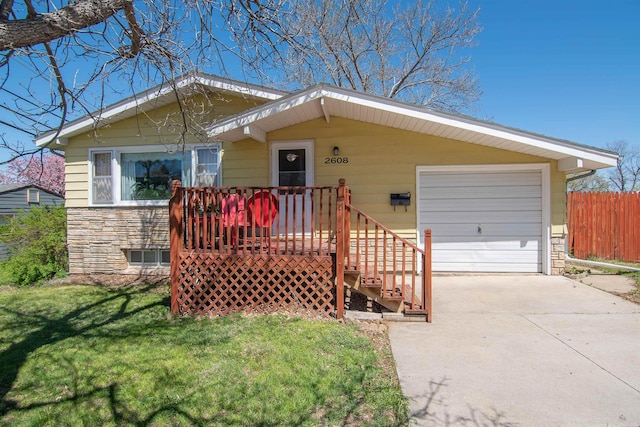 2608 Maple Ave, Rapid City, SD 57701 - single story home with fence, stone siding, driveway, a garage, and a front lawn