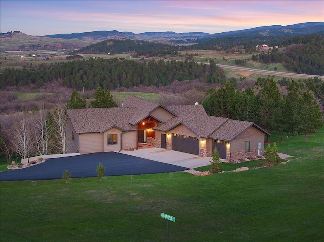 view of front of property with stone siding, an attached garage, and a mountain view