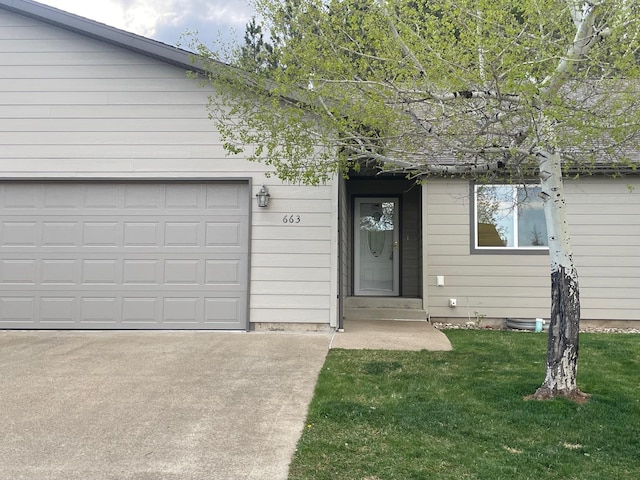 view of front of house featuring concrete driveway, a garage, and a front lawn