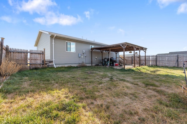 back of house featuring a yard and a fenced backyard