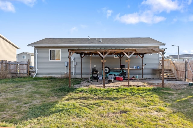 rear view of property featuring a yard, fence, and a patio area