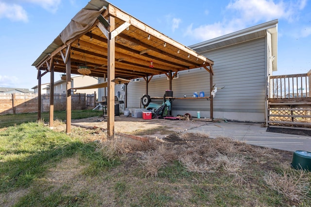 view of parking / parking lot featuring fence and a carport