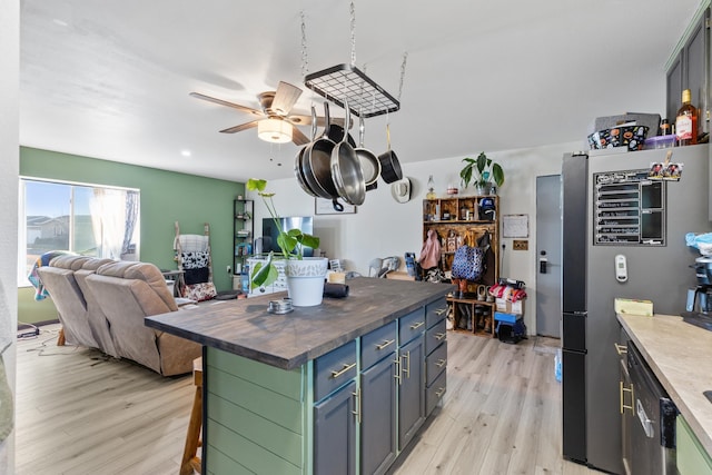 kitchen with wooden counters, a ceiling fan, stainless steel appliances, open floor plan, and light wood-type flooring
