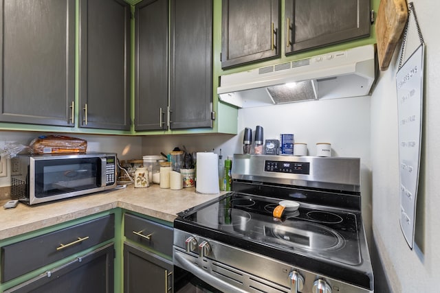 kitchen with under cabinet range hood, stainless steel appliances, and light countertops