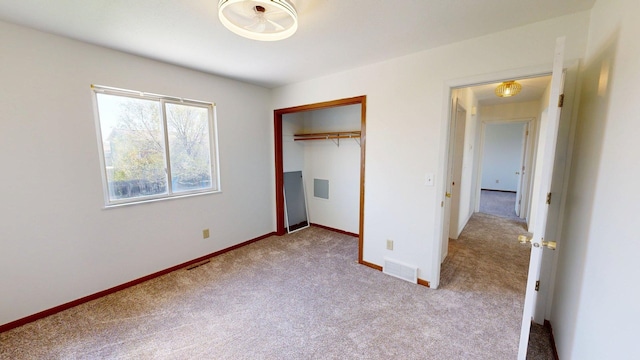 unfurnished bedroom featuring carpet, baseboards, and a closet