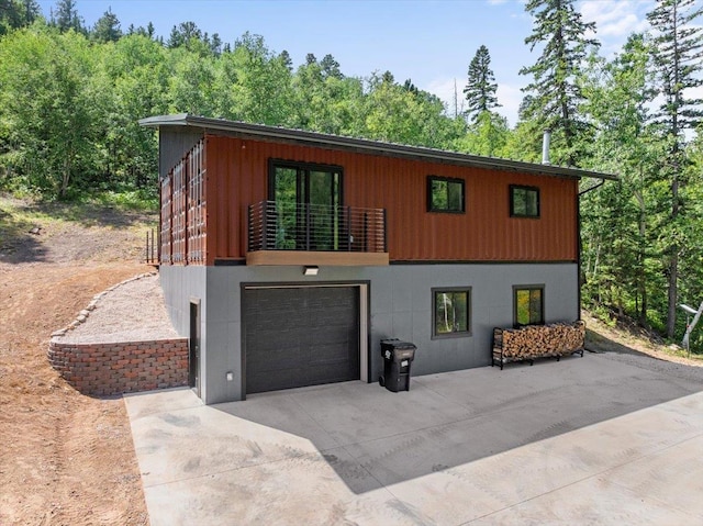 view of front of property featuring a balcony, driveway, and an attached garage