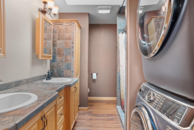 1245 Pine Cone Ln, Rapid City, SD 57701 - bathroom featuring stacked washing machine and dryer, wood finished floors, baseboards, and curtained shower