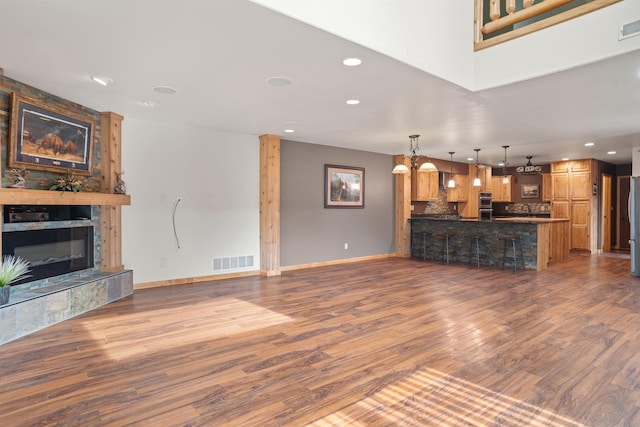 1245 Pine Cone Ln, Rapid City, SD 57701 - unfurnished living room featuring recessed lighting, a tile fireplace, wood finished floors, baseboards, and a sink