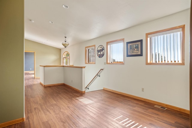 1245 Pine Cone Ln, Rapid City, SD 57701 - unfurnished room featuring wood finished floors, baseboards, vaulted ceiling, and recessed lighting