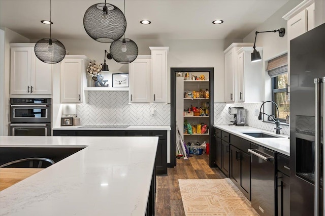 kitchen with a sink, appliances with stainless steel finishes, white cabinetry, open shelves, and recessed lighting