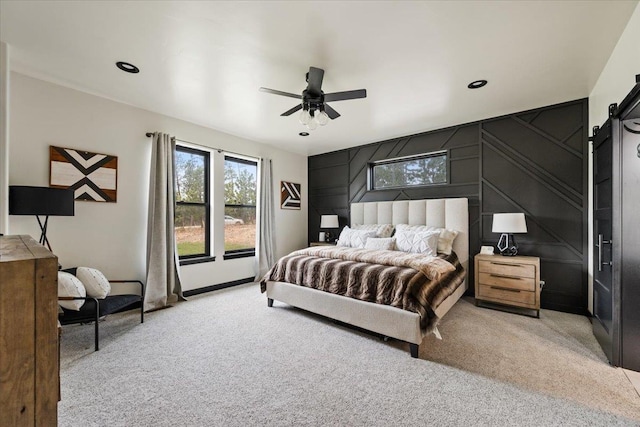 bedroom with a barn door, light carpet, a ceiling fan, and recessed lighting