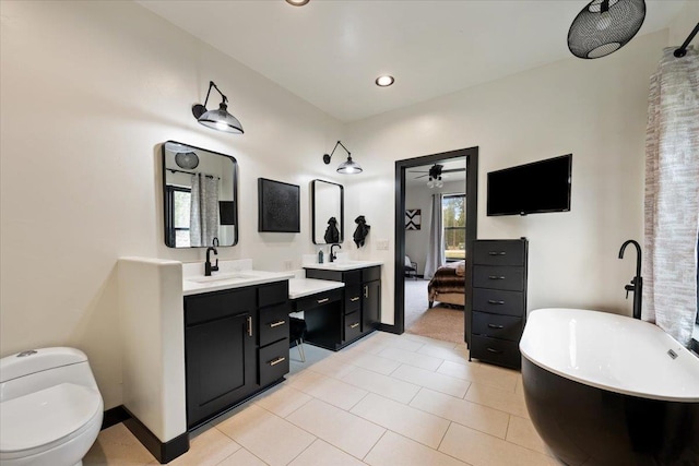 ensuite bathroom with a soaking tub, vanity, toilet, tile patterned floors, and recessed lighting