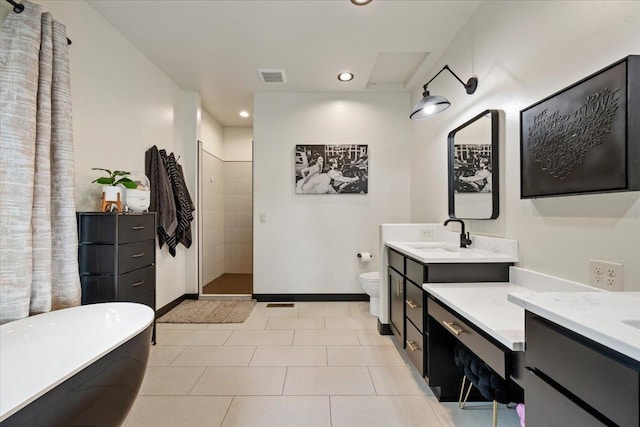 bathroom featuring a tile shower, recessed lighting, a freestanding tub, tile patterned floors, and two vanities