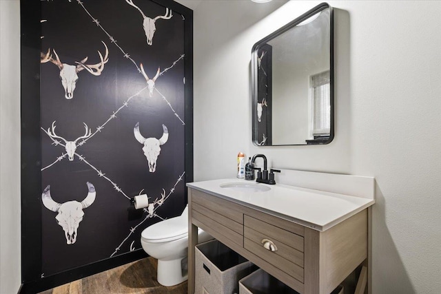 bathroom featuring wood finished floors, toilet, and vanity