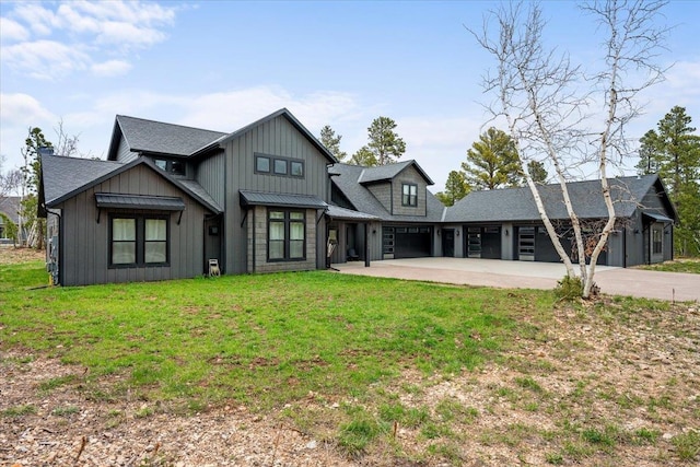 back of house with driveway, board and batten siding, a lawn, a garage, and a shingled roof