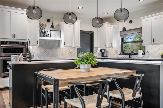 kitchen with open shelves, backsplash, light countertops, white cabinetry, and recessed lighting
