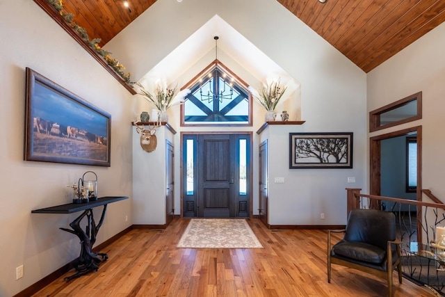 entryway featuring wood finished floors, high vaulted ceiling, wooden ceiling, and baseboards