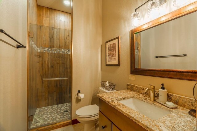 full bath with a shower stall, toilet, and vanity