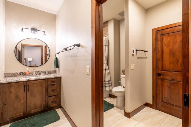 bathroom with toilet, vanity, a shower with curtain, tile patterned floors, and baseboards
