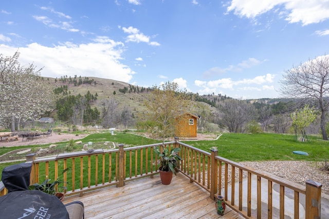 6494 Blake Rd, Rapid City, SD 57702 - wooden deck with an outbuilding, a storage unit, a lawn, and a mountain view