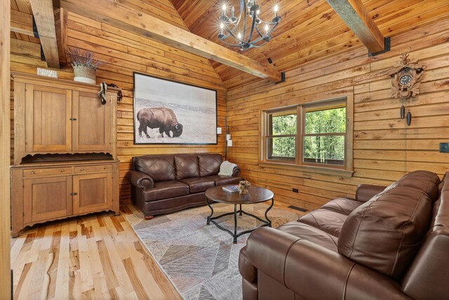 living room featuring wood walls, light wood finished floors, a chandelier, and wood ceiling